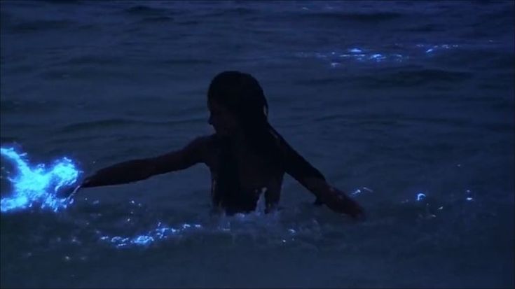 a person in the water with their arm out and one hand outstretched up to touch something