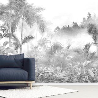 a couch sitting in front of a wall mural with palm trees and bushes on it