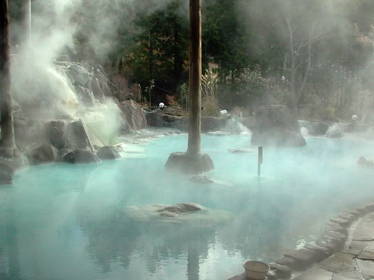 the water is blue and there are steam rising from it's pools in the park