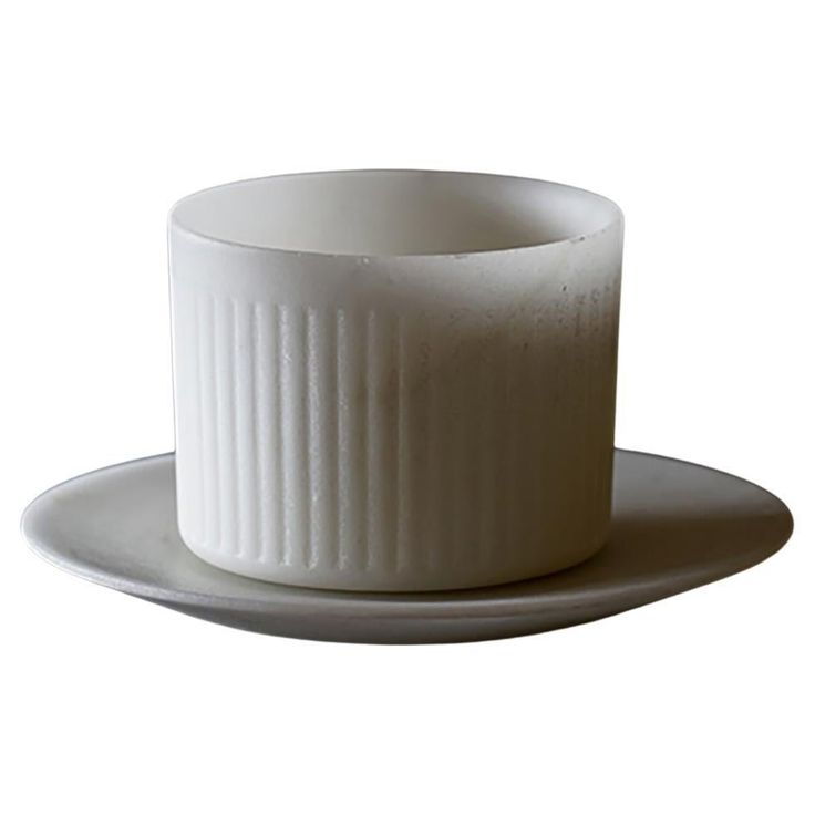 a white cup and saucer on a plate