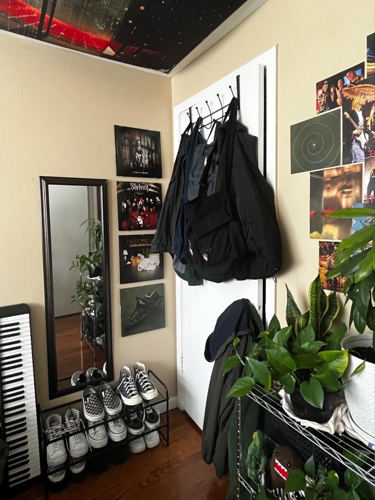 a room filled with shoes and plants next to a wall covered in pictures on the walls