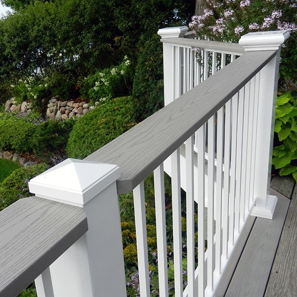 a white railing on a wooden deck overlooking the water