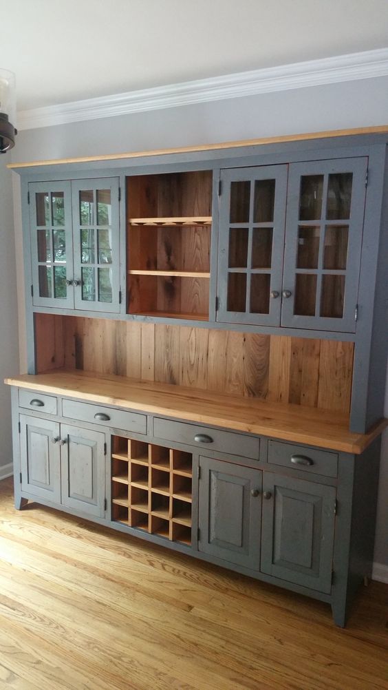 a large wooden cabinet with glass doors and drawers in a room that has hard wood flooring