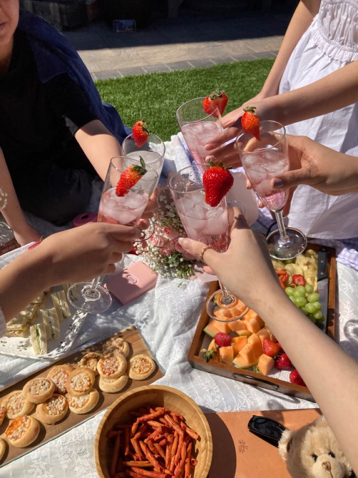 a group of people sitting at a table with food and drinks