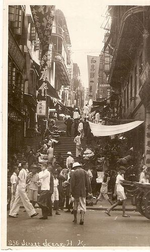 an old black and white photo of people walking down the street