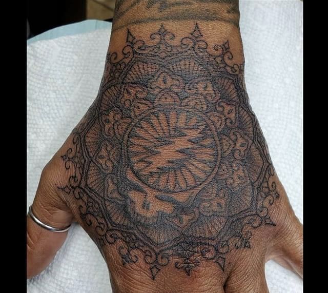 a person's hand with a tattoo on it and an intricate design in the middle