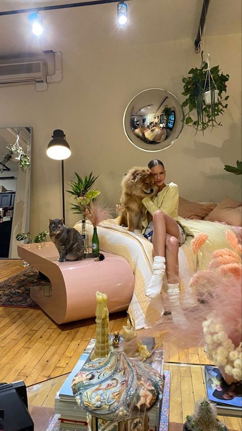 a woman sitting on a couch with a dog in her lap, surrounded by plants