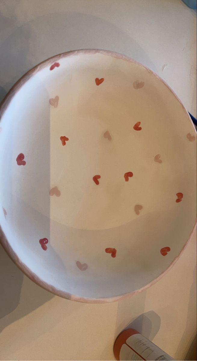 a white bowl with hearts painted on it