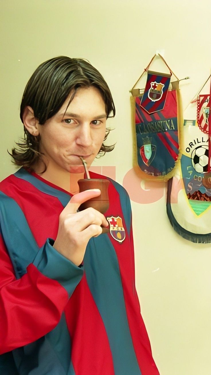 a man with a toothbrush in his mouth wearing a red, blue and green shirt