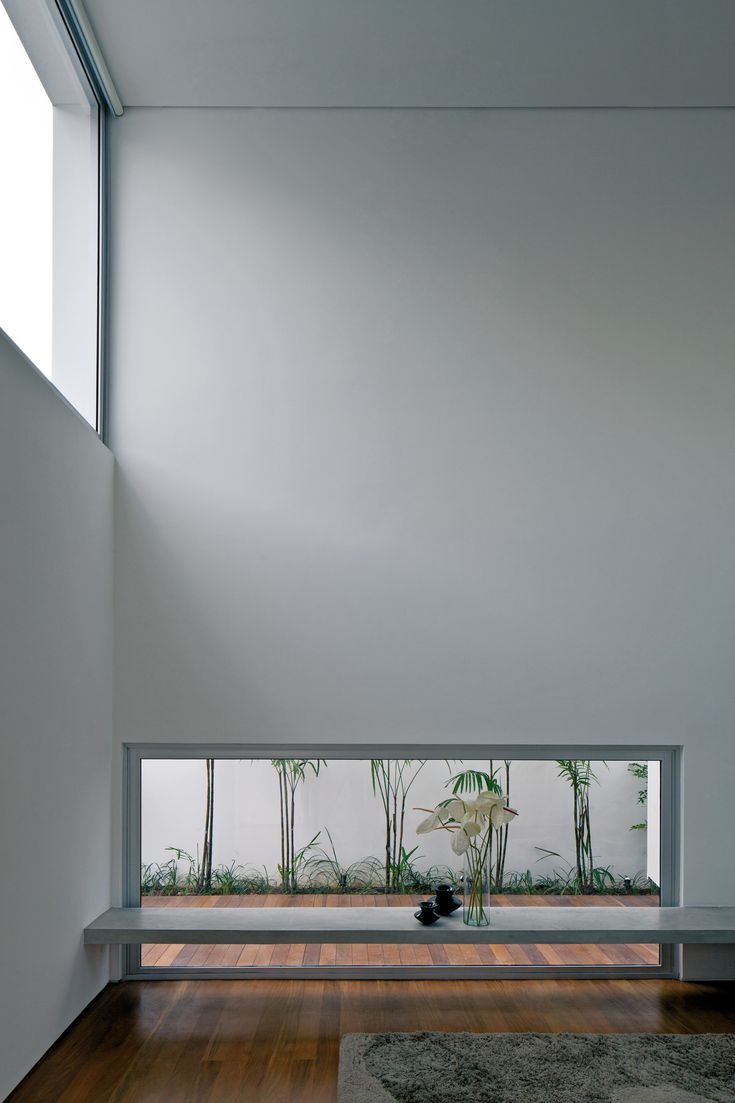 an empty room with wood floors and white walls is seen from the inside looking out