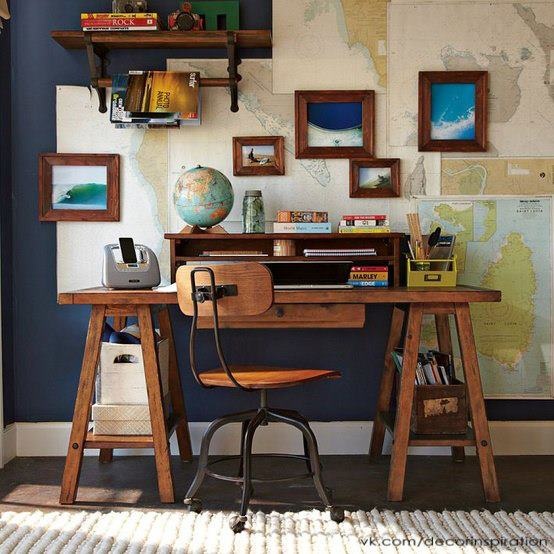 a desk with a wooden chair in front of a map on the wall above it