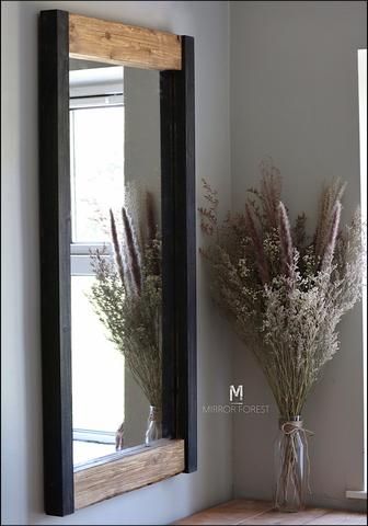 a vase filled with flowers sitting next to a mirror