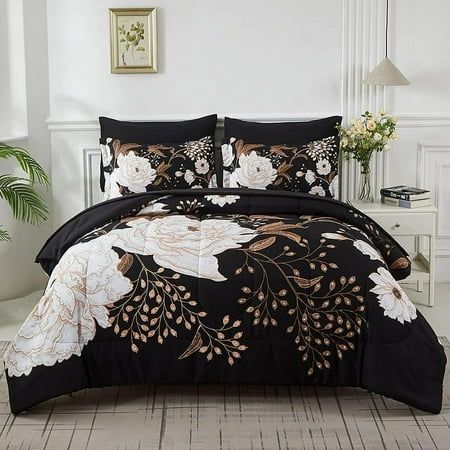 a black and white comforter set with flowers on the front, in a bedroom