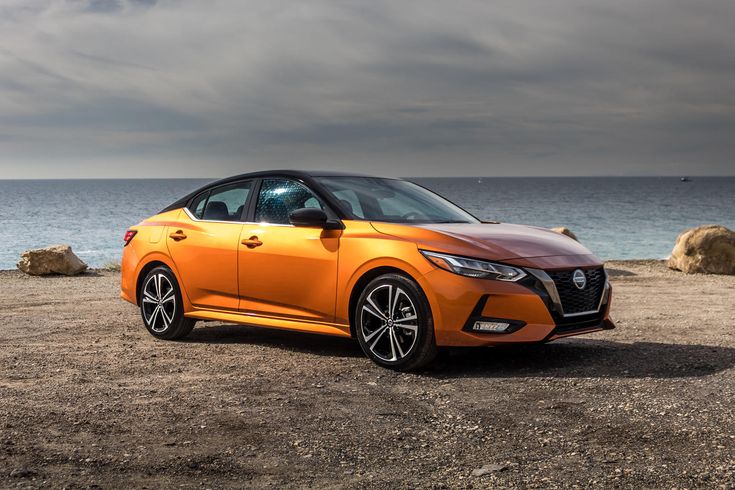 an orange car is parked on the beach