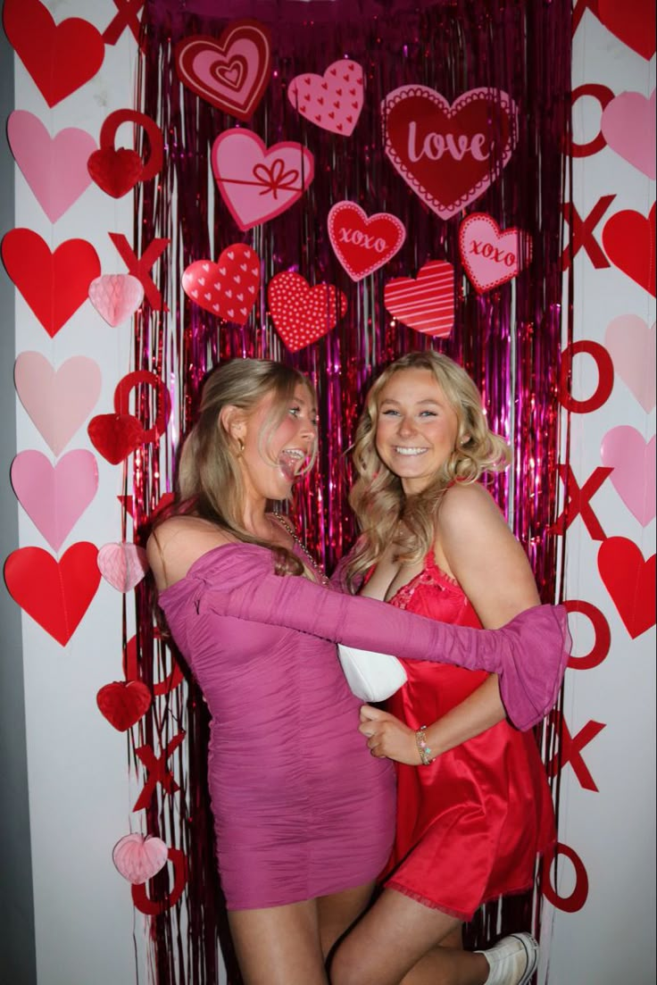 two women are hugging each other in front of valentine's day decorations and streamers