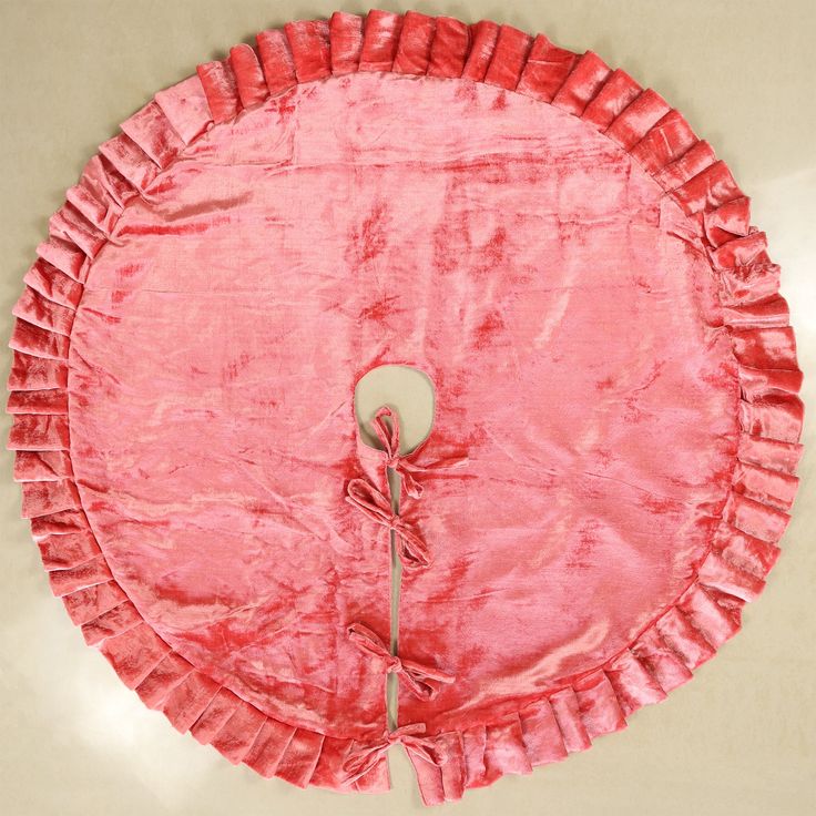 a round pink cloth with ruffles on the edges and a white button at the center