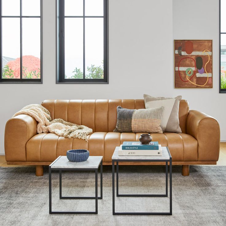 a living room with two couches and a coffee table in front of the window