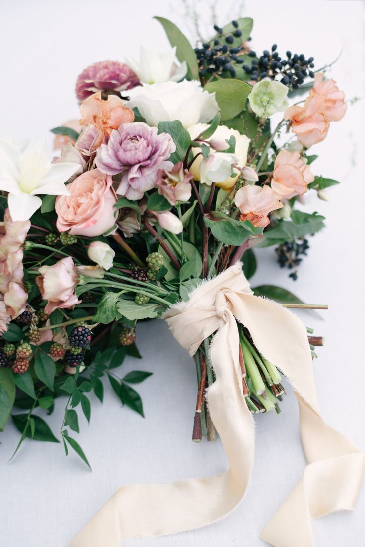 a bouquet of flowers is tied up on the table