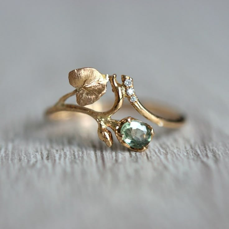 Truly romantic, delicate sapphire and diamond ring with the botanical motif of green flower bud and twig with leaves. This sapphire and diamond leaf wedding ring is handmade with special care for details. I created it with the thought of women who love nature, going to the woods, or hiking mountains.  And if you live far away from it, in a crowded city, the look at the jewelry piece will bring harmony to your life peace and quiet.   And a few details about the stone, material, shipping, and pack Fairy Inspired Wedding Rings, Unique Three Stone Ring, Plant Inspired Engagement Rings, No Traditional Wedding Rings, Wedding Ring Nature Inspired, Plant Engagement Ring, Cottagecore Rings Engagement, Elven Engagement Rings, Nature Themed Engagement Rings