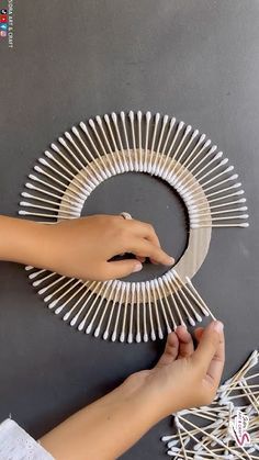 someone is making a paper plate wreath out of clothes pins