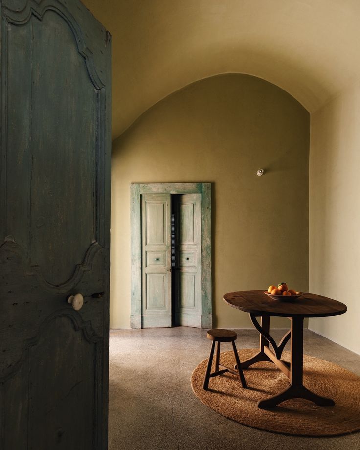 a table and two chairs in a room with an archway leading to the bedroom door