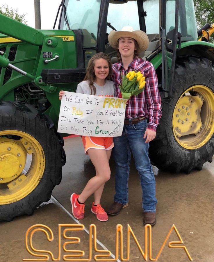 two people standing in front of a tractor with a sign that says,'get out is