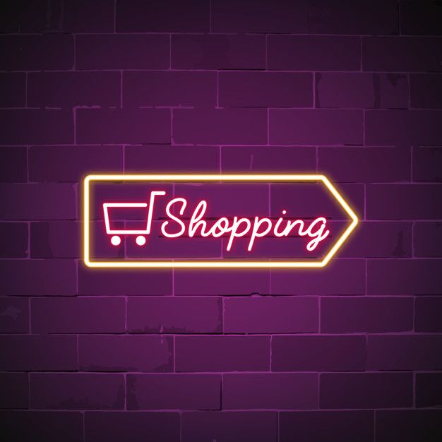 a neon sign that says shopping on it in front of a brick wall with a shopping cart