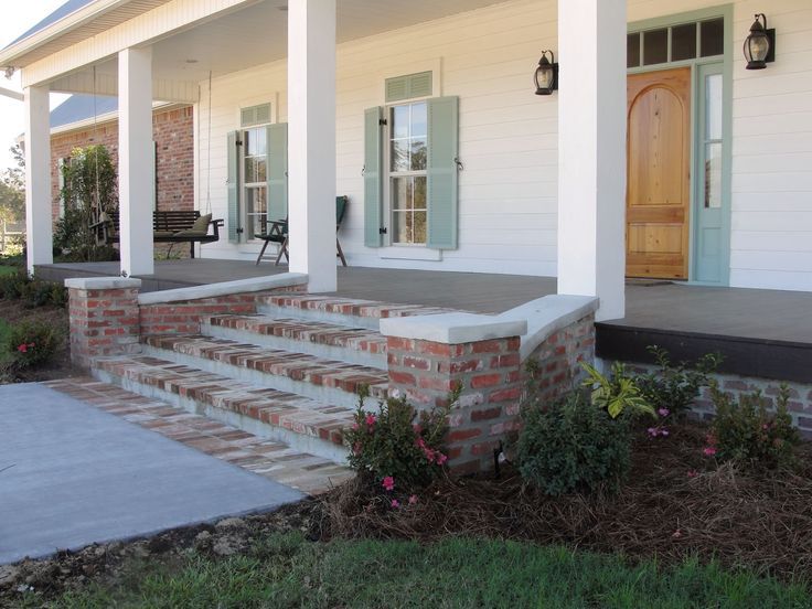 the front porch of a white house with steps leading up to it's door