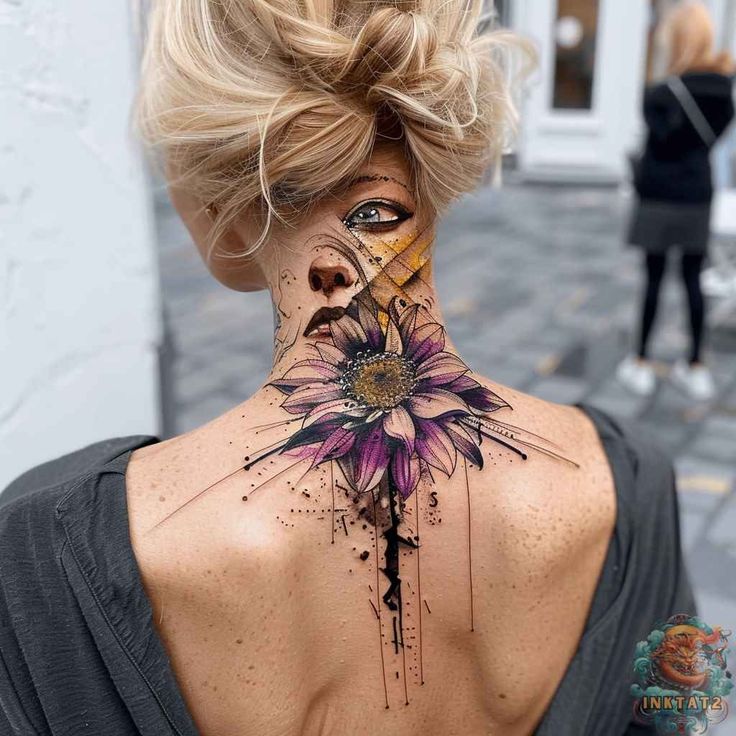 a woman's back neck with a flower tattoo on her left shoulder and an artistic cross in the middle