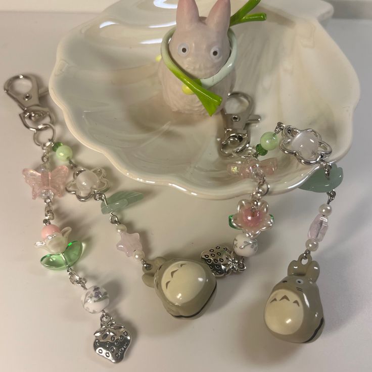 a white plate topped with charms next to a bunny figurine on top of it