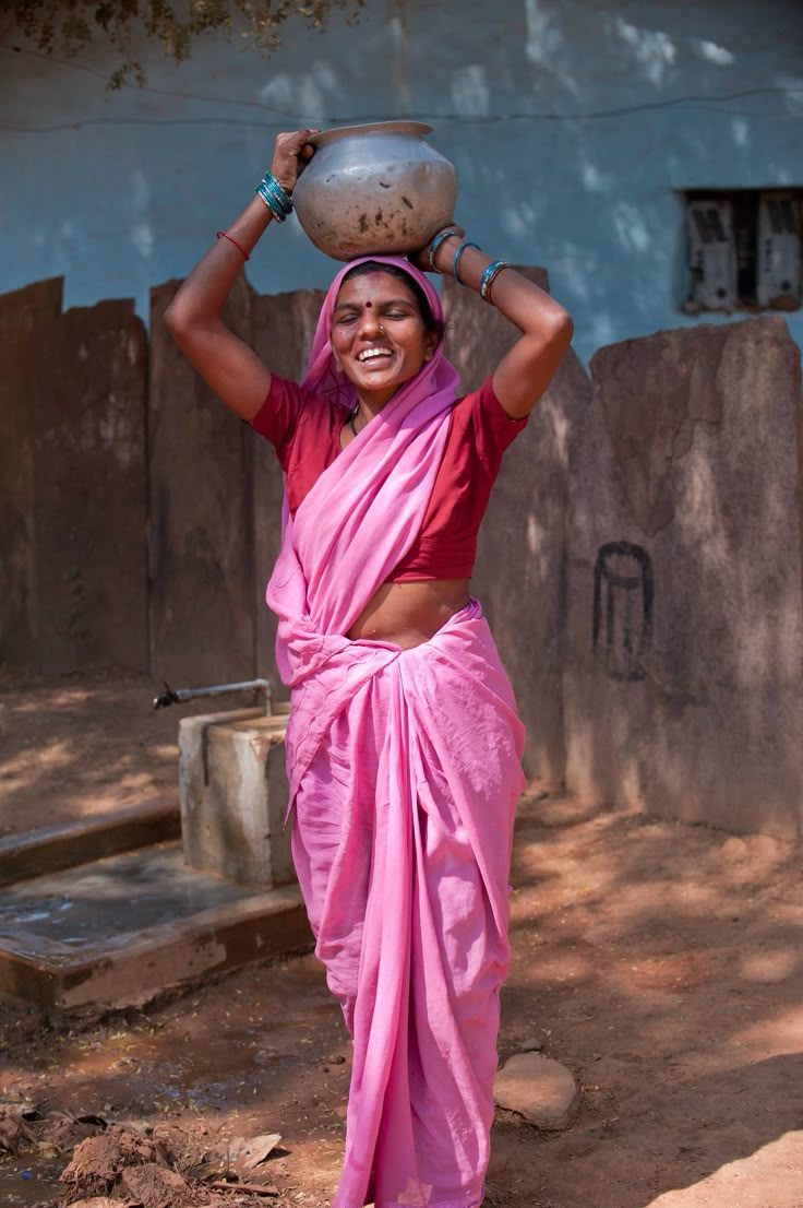 a woman carrying a pot on her head