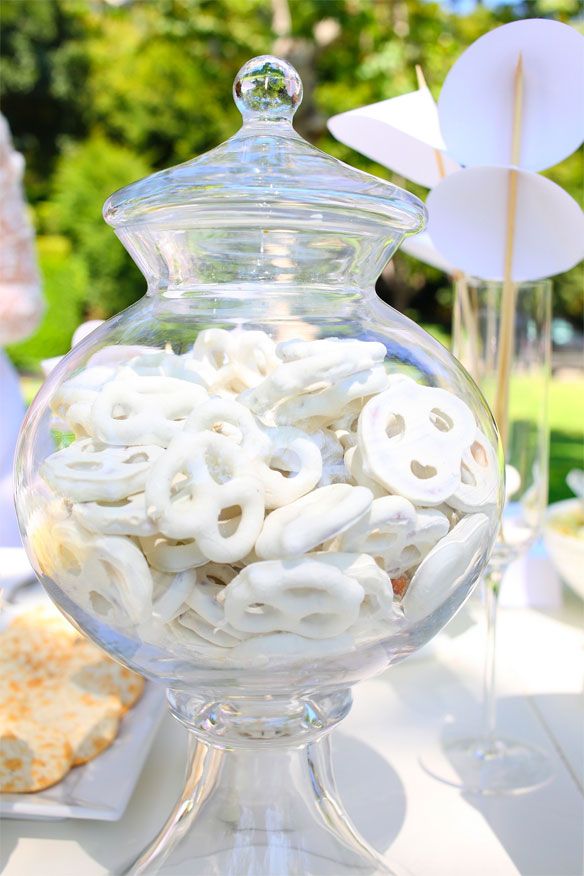 a glass vase filled with white buttons on top of a table