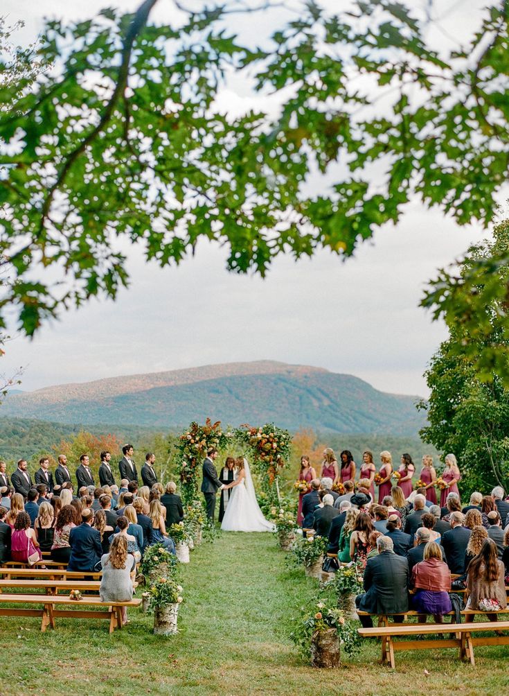 an outdoor wedding ceremony with the bride and groom standing at the end of the aisle