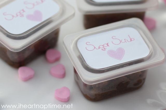 homemade brown sugar scrubs in plastic containers with pink and white candies around them