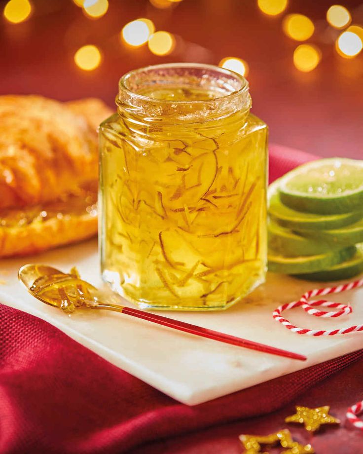 a glass jar filled with liquid sitting on top of a white plate next to cookies