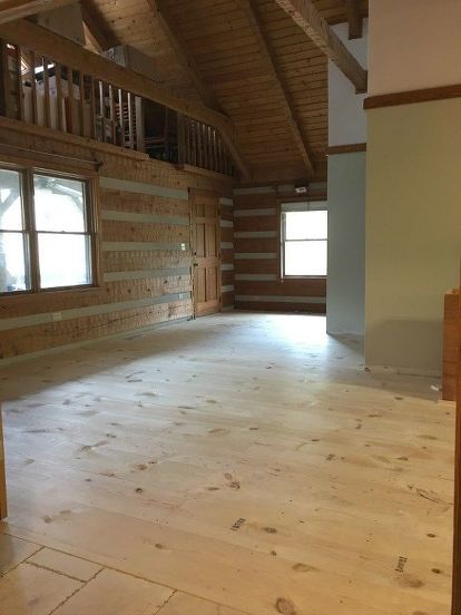 an empty room with wood floors and windows