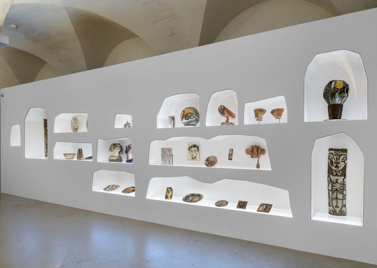 a wall that has some shelves on it with various items in the middle and different shapes