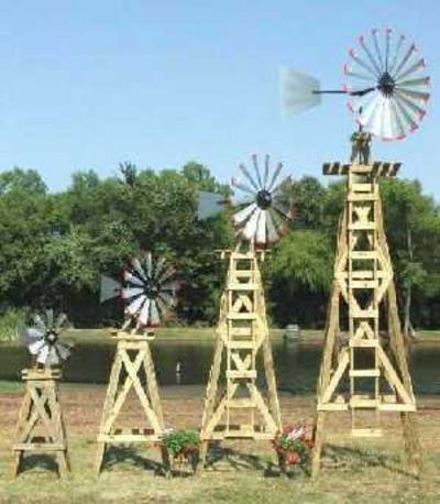 three wooden windmills sitting on top of a grass covered field