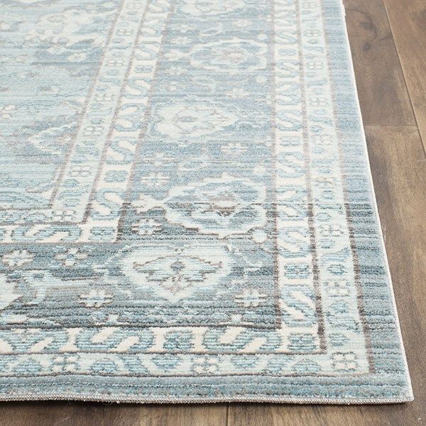 a blue and white rug with an ornate design on the bottom, sitting on a wooden floor