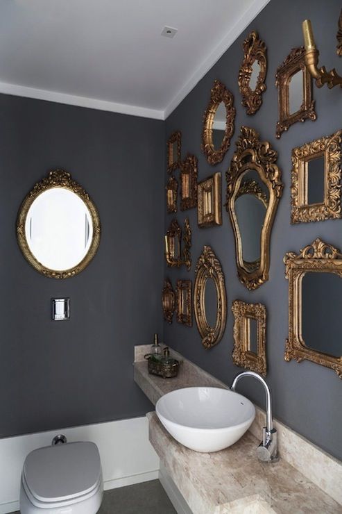 a bathroom with several mirrors on the wall and a sink in front of an oval mirror