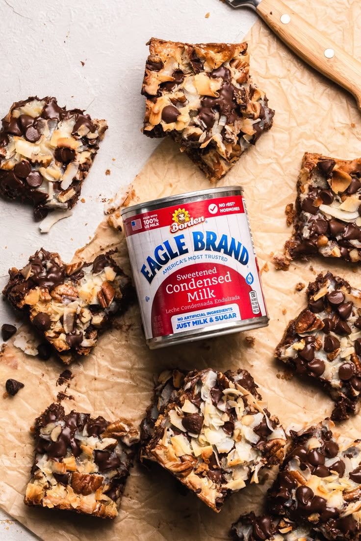 a can of eagle brand chocolate chip cookie dough next to some cookies and spoons