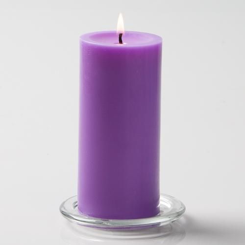 a purple candle sitting on top of a glass holder