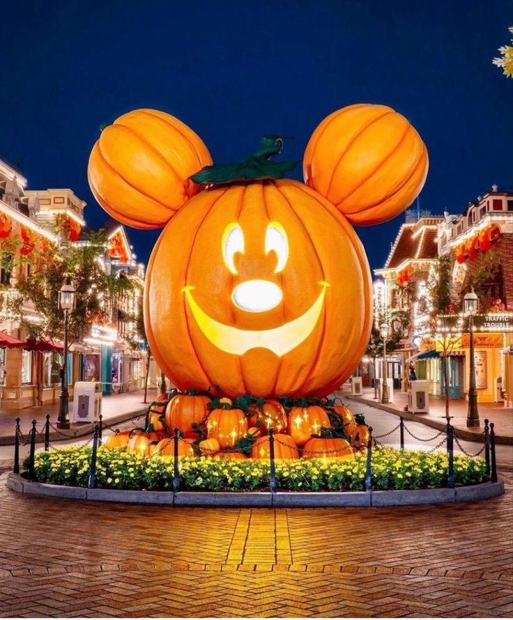 a mickey mouse pumpkin is lit up at night