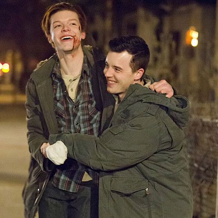 two men standing next to each other on the street