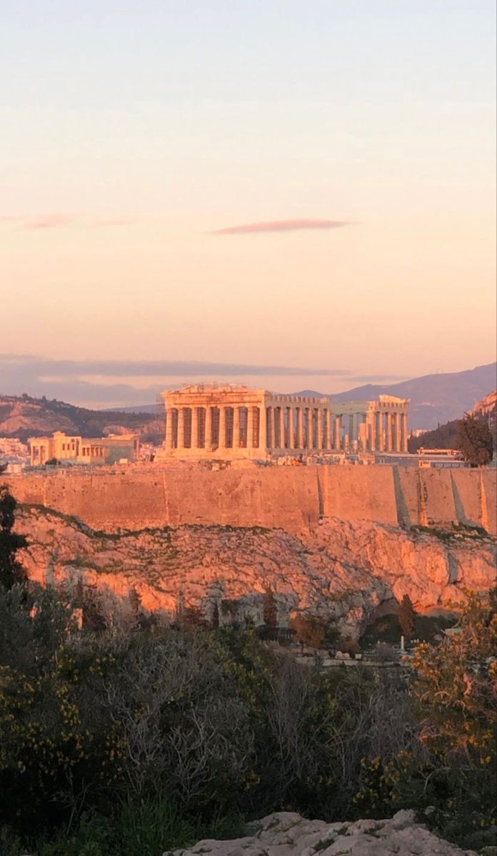 the parthenion and parthenon in the distance, as seen from the acrobatic ruins at sunset