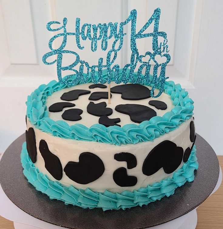 a birthday cake with blue frosting and black polka dots