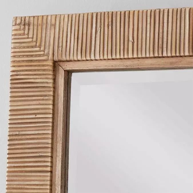 a wooden frame mirror hanging on the wall