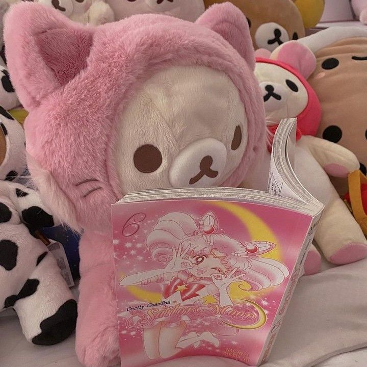 there are many stuffed animals that are on the bed and one is reading a book