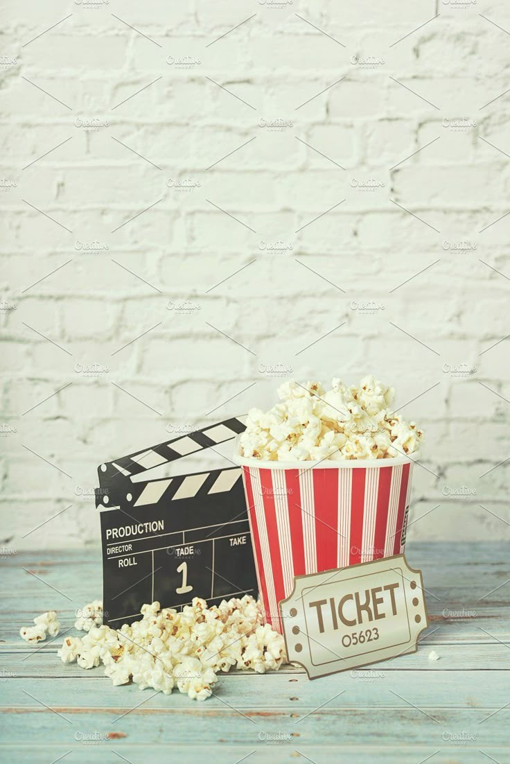 an old movie clapper and popcorn on a wooden table