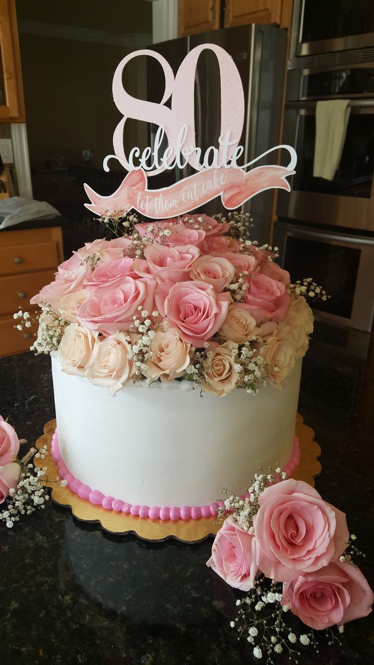 a white cake with pink flowers and the number 80 on top